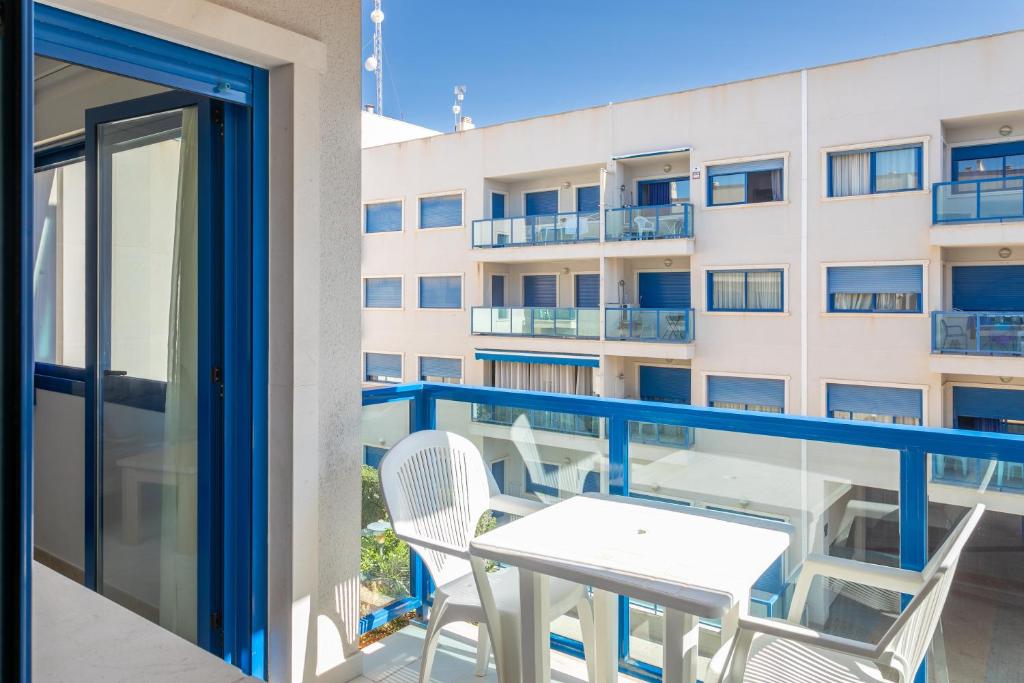 een balkon met een tafel en stoelen en een gebouw bij Alicante Hills in Alicante