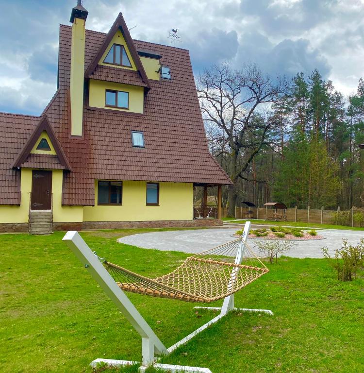 a house with a hammock in front of a house at Complex MAYARIV in Makariv