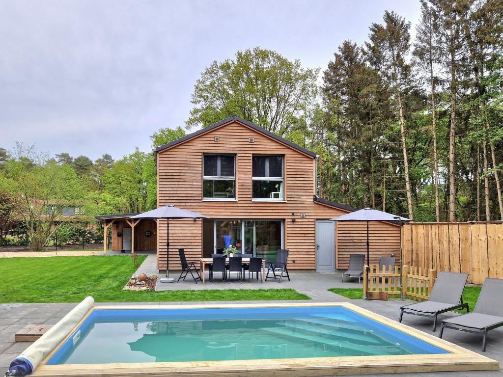 una casa con piscina en el patio en Waldhaus Tiedtke, en Wedemark