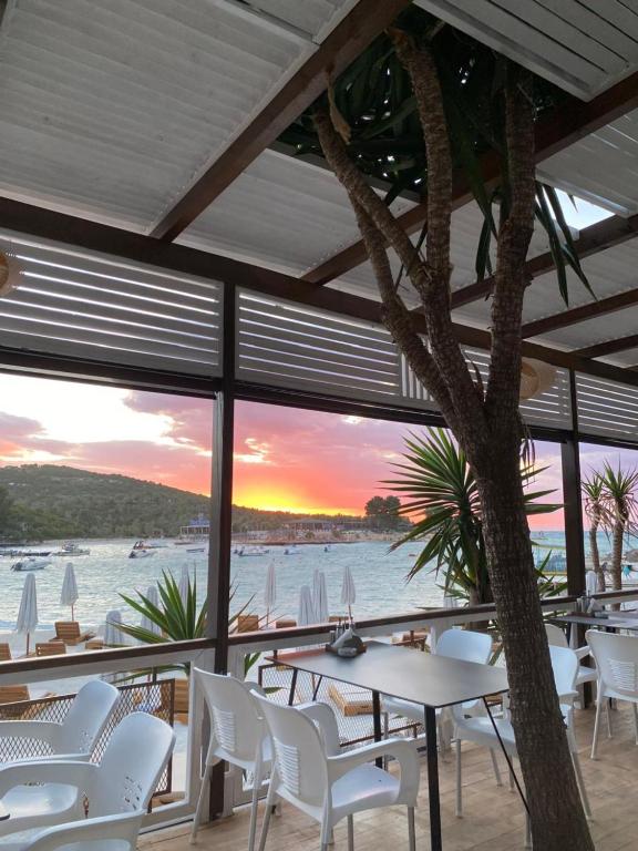 uma sala de jantar com vista para o oceano em HOTEL DENOEL em Ksamil