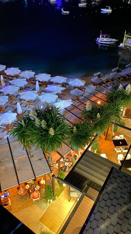 uma vista superior para uma praia com guarda-sóis e mesas em HOTEL DENOEL em Ksamil