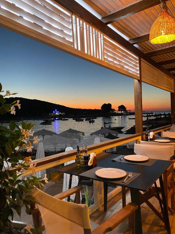 uma sala de jantar com vista para a água em HOTEL DENOEL em Ksamil