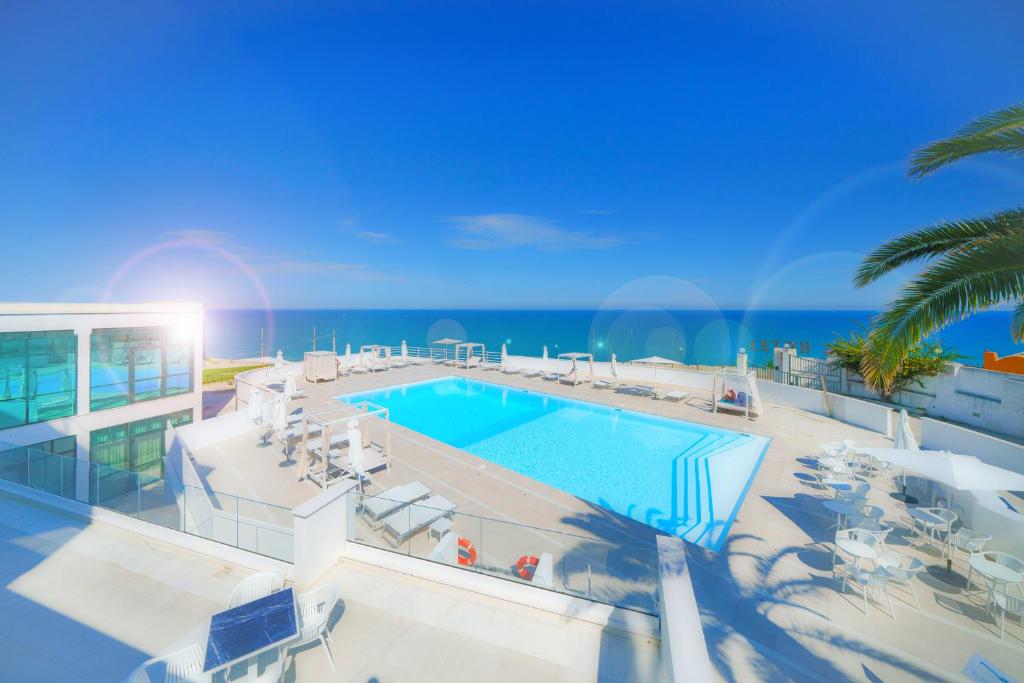 a swimming pool with the ocean in the background at Rodi Resort in Rodi Garganico