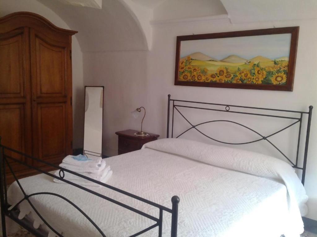 ドルチェアックアにあるBeB I Girasoliのベッドルーム1室(ベッド1台付)が備わります。壁には絵画が飾られています。