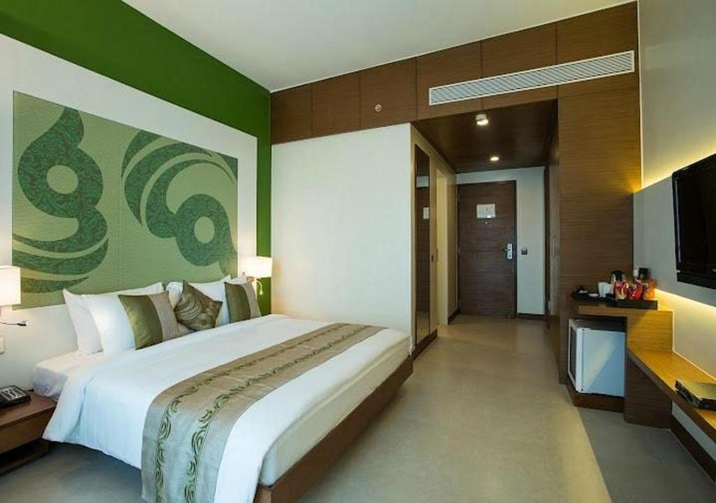 Hotel Atlantis suites Near Delhi Airport في نيودلهي: غرفة نوم بسرير كبير وتلفزيون بشاشة مسطحة