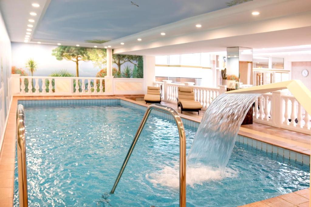 a pool with a water slide in a house at Golf- und Wellnesshotel Amtsheide in Bad Bevensen