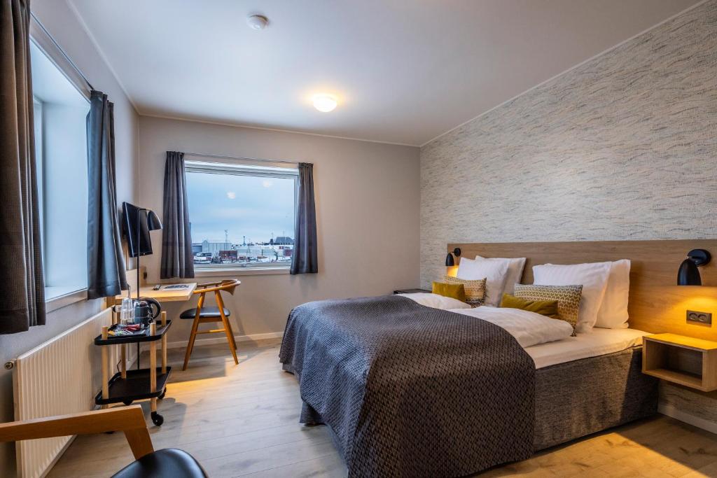 ein Hotelzimmer mit einem Bett und einem Fenster in der Unterkunft HOTEL SØMA Aasiaat in Aasiaat