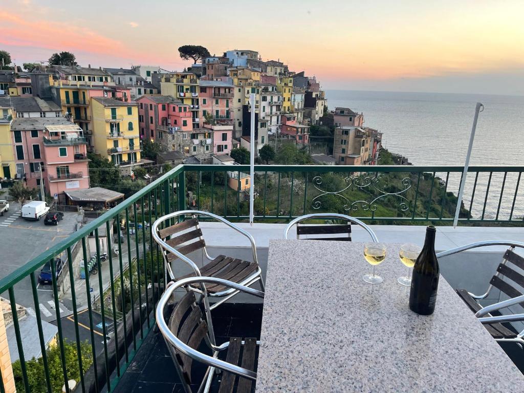 una mesa con 2 copas de vino en el balcón en Appartamento Isola - In the center with Terrace - sea view & AC en Corniglia