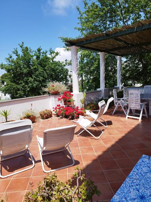 a patio with lawn chairs and a pergola at Casa Le Anfore in Anacapri