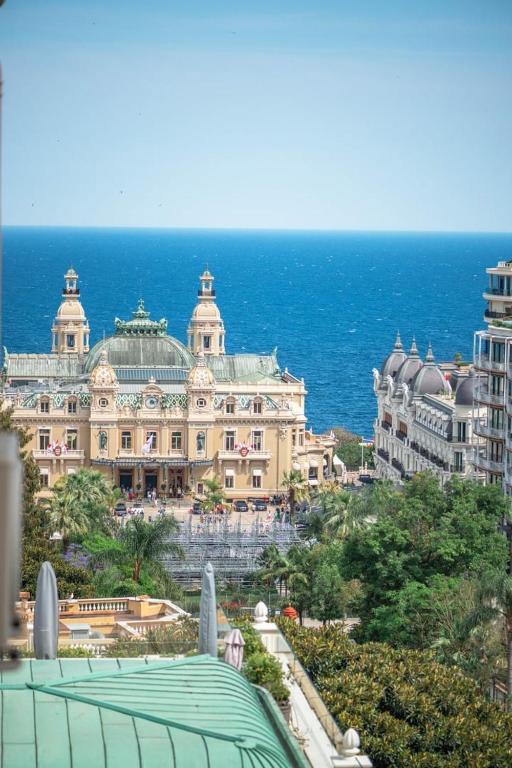 un grand bâtiment en face de l'océan dans l'établissement Le COQ Charlene - Monaco à 50m - New, à Beausoleil