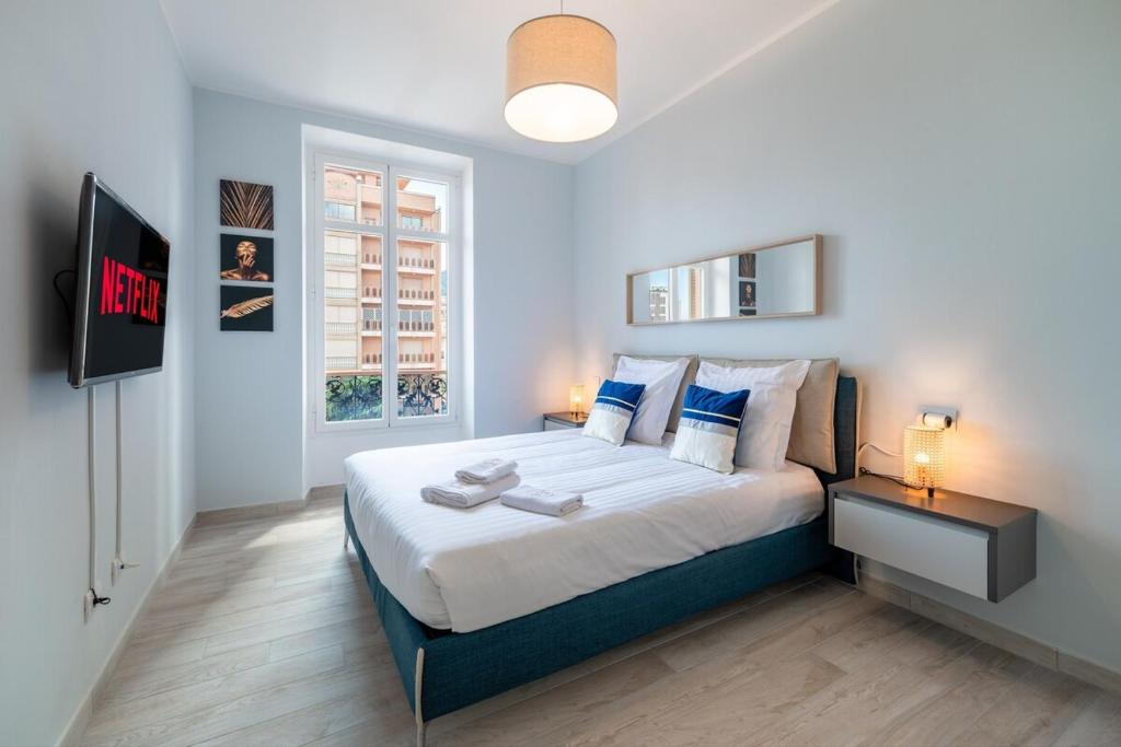 een slaapkamer met een groot bed en een televisie bij Le COQ Charlene - Monaco à 50m - New in Beausoleil