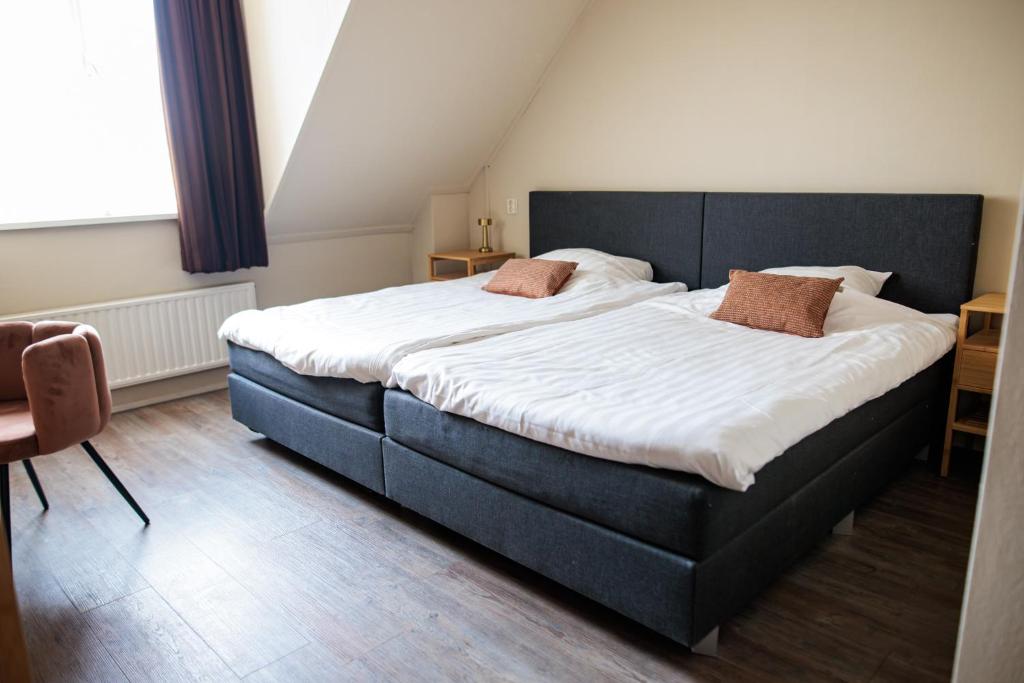 duże łóżko z dwoma poduszkami w sypialni w obiekcie Hotel Restaurant BEAU w mieście Bergeijk