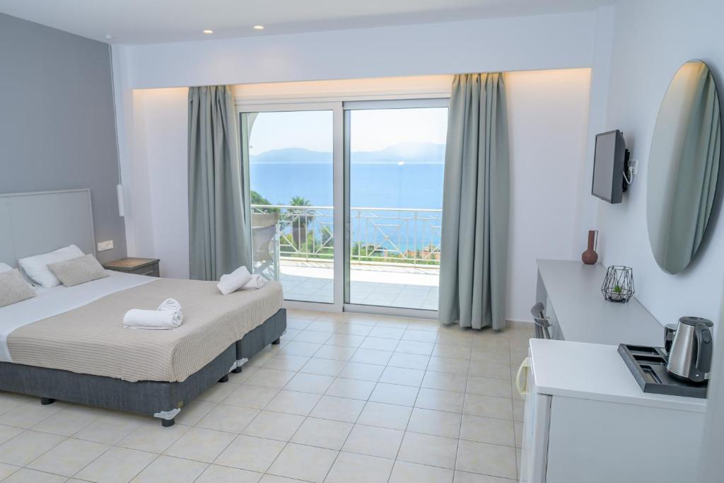 a bedroom with a bed and a view of the ocean at KOSTA MARIA in Paleros