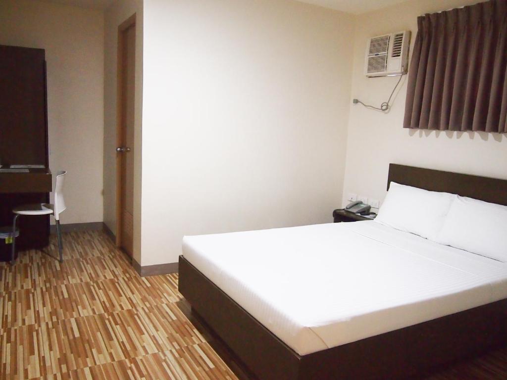 Postel nebo postele na pokoji v ubytování Emerald Suites CDO