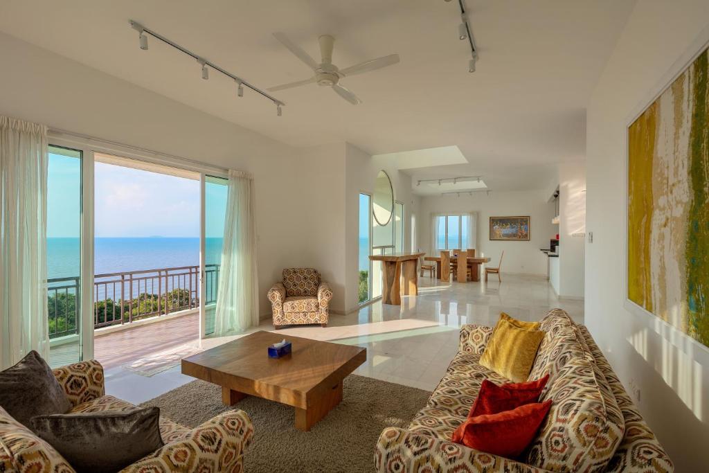 a living room with a couch and a table at Panoramic Seaview Holiday Home - Batu Ferringhi in Batu Ferringhi
