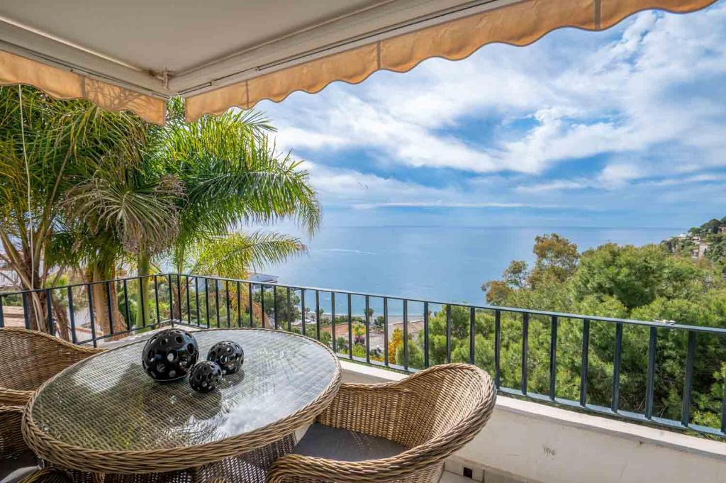 una mesa y sillas en un balcón con vistas al océano en Exotic Villa Rest and Pool, en La Herradura