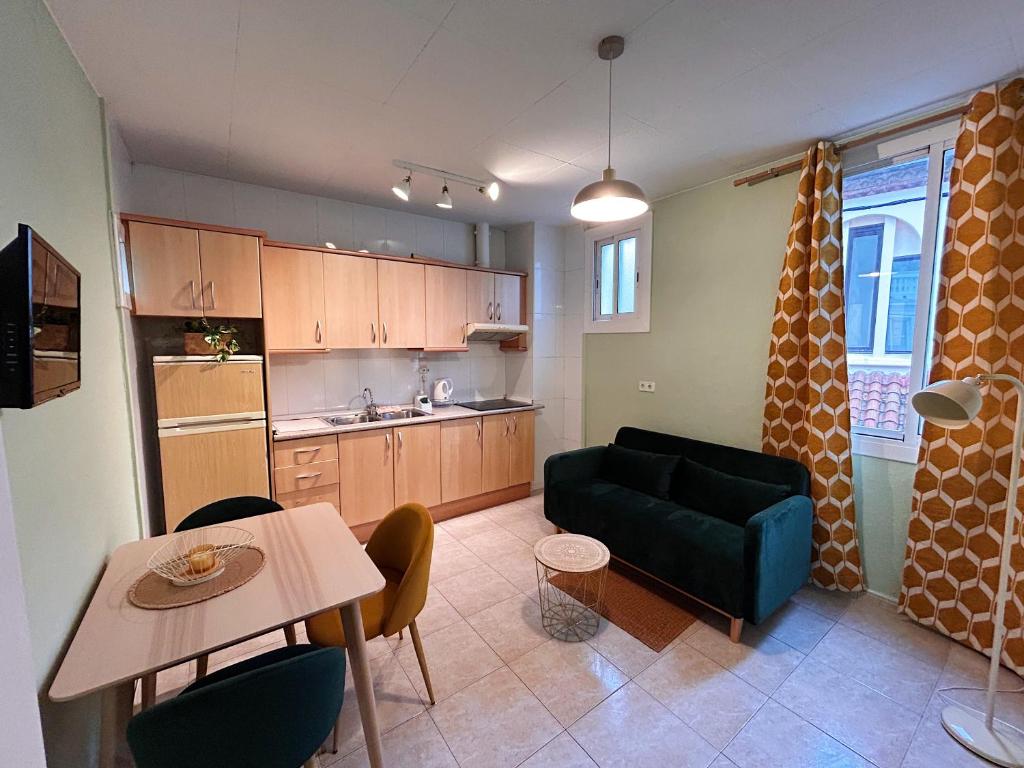 a kitchen and living room with a couch and a table at Central Market Apartment in Calella
