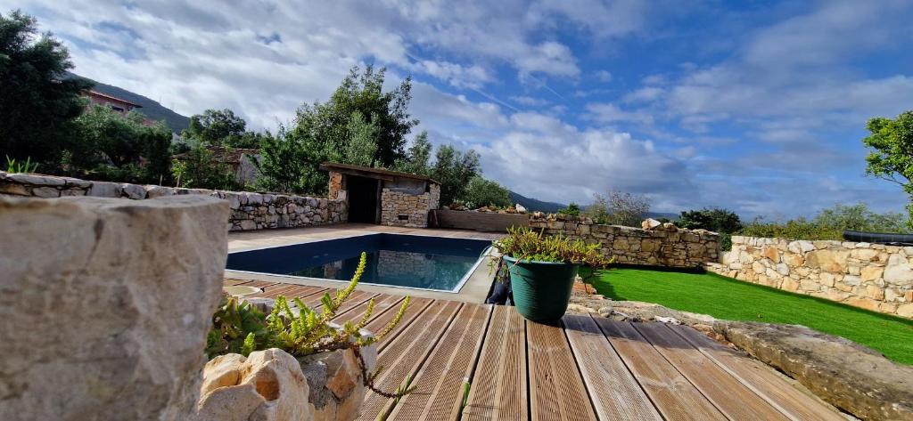 un patio trasero con piscina y pared de piedra en Casa do casal POIOS, en Pombal