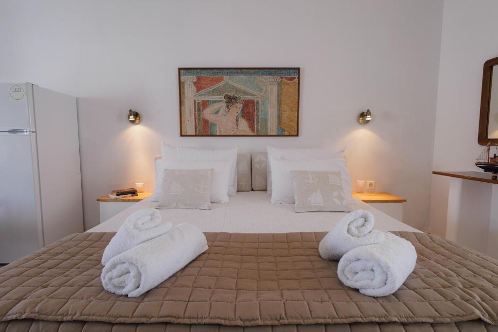 a bedroom with a bed with towels on it at Studios Eliza in Livadi