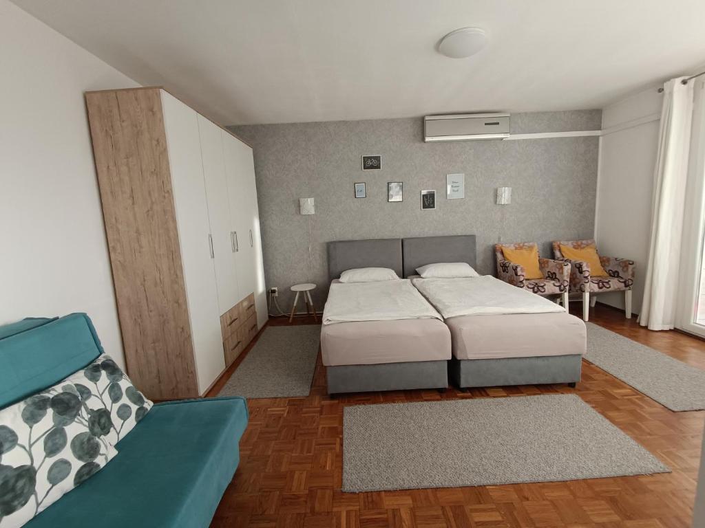 a bedroom with two beds and a couch in it at Aura apartman Sarajevo in Sarajevo