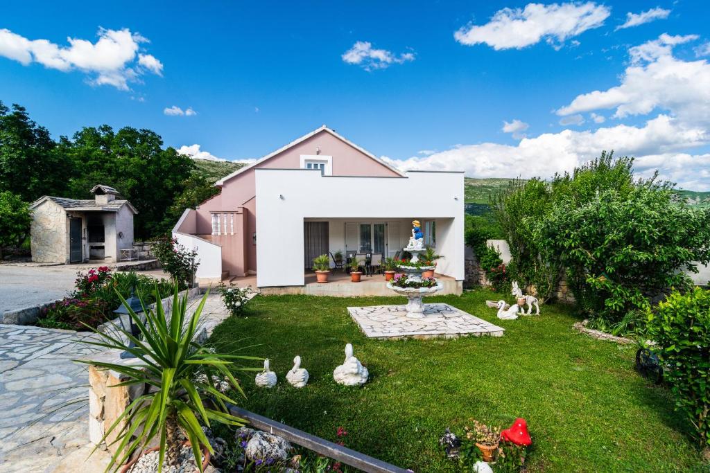 a house with chickens in the yard at Three-Bedroom Holiday Home in Dabar in Dabar