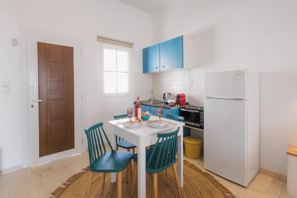 a kitchen with a table and chairs and a refrigerator at Studios Eliza in Livadi
