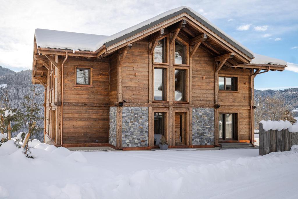 a log cabin in the snow in the winter at Chalet Getois in Les Gets