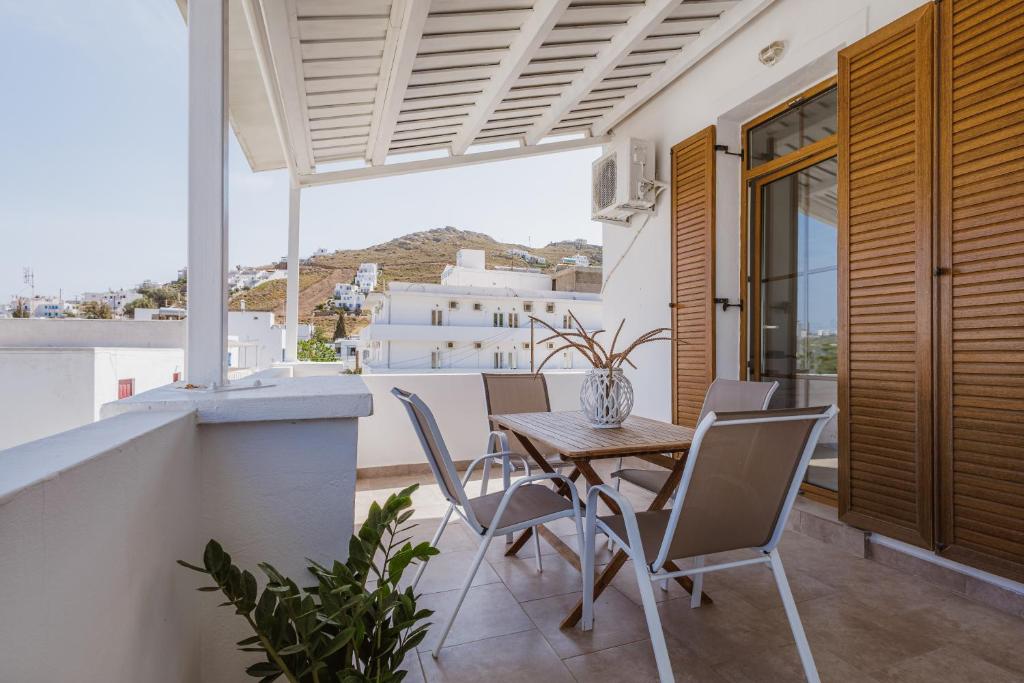 a dining room with a table and chairs on a balcony at Studios Eliza in Livadi