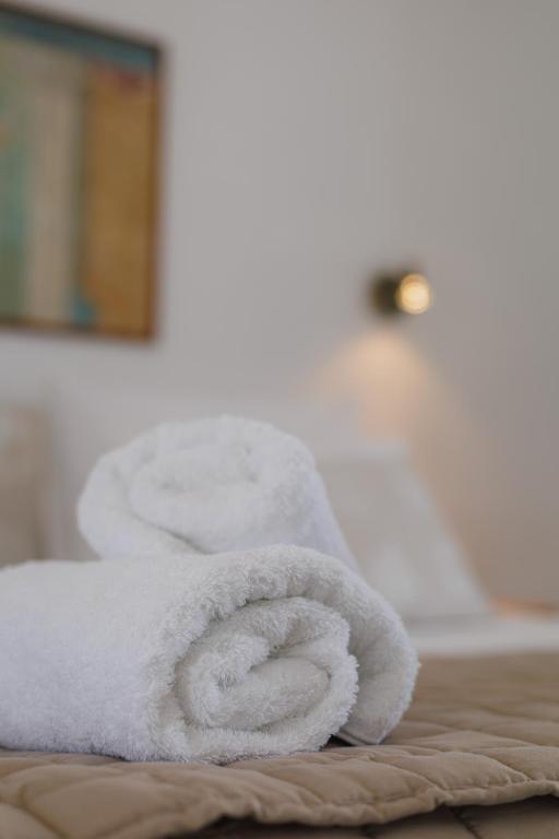 a pile of white towels sitting on top of a bed at Studios Eliza in Livadi