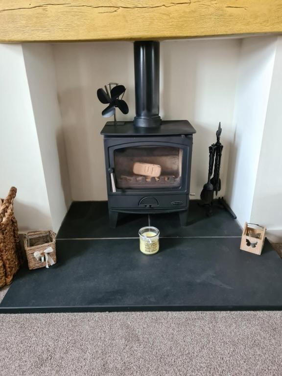 a fireplace in a room with a stove at RAWSON COTTAGE LOVELY 2 BEDROOM SEMI RURAL in Stranraer