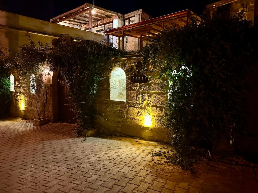an alley with a stone wall at night at Zanta Suite Hotel in Urgup