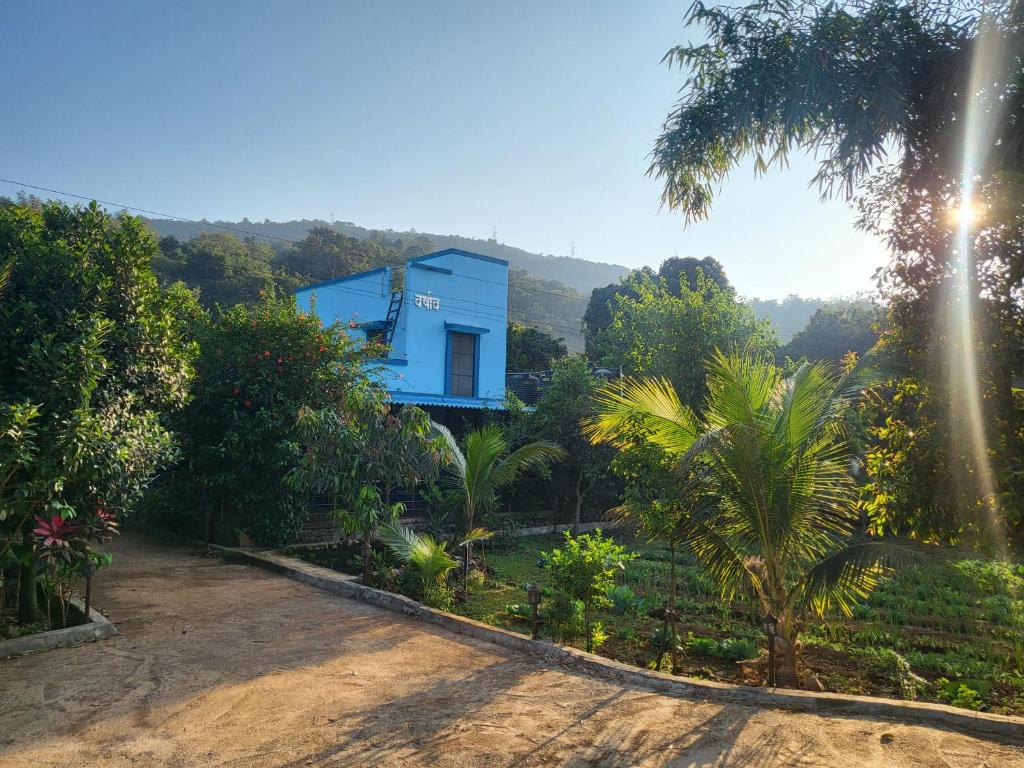 a blue house in the middle of a forest at Varshav Villa in Pune