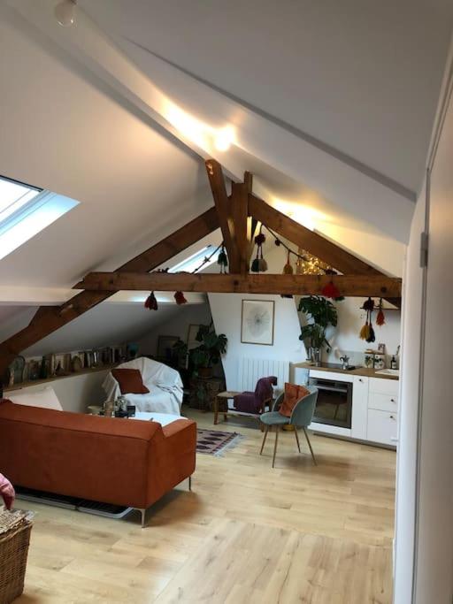 un salon avec un canapé et une cuisine dans l'établissement Luminous and cosy loft - close to olympic games, à Saint-Ouen