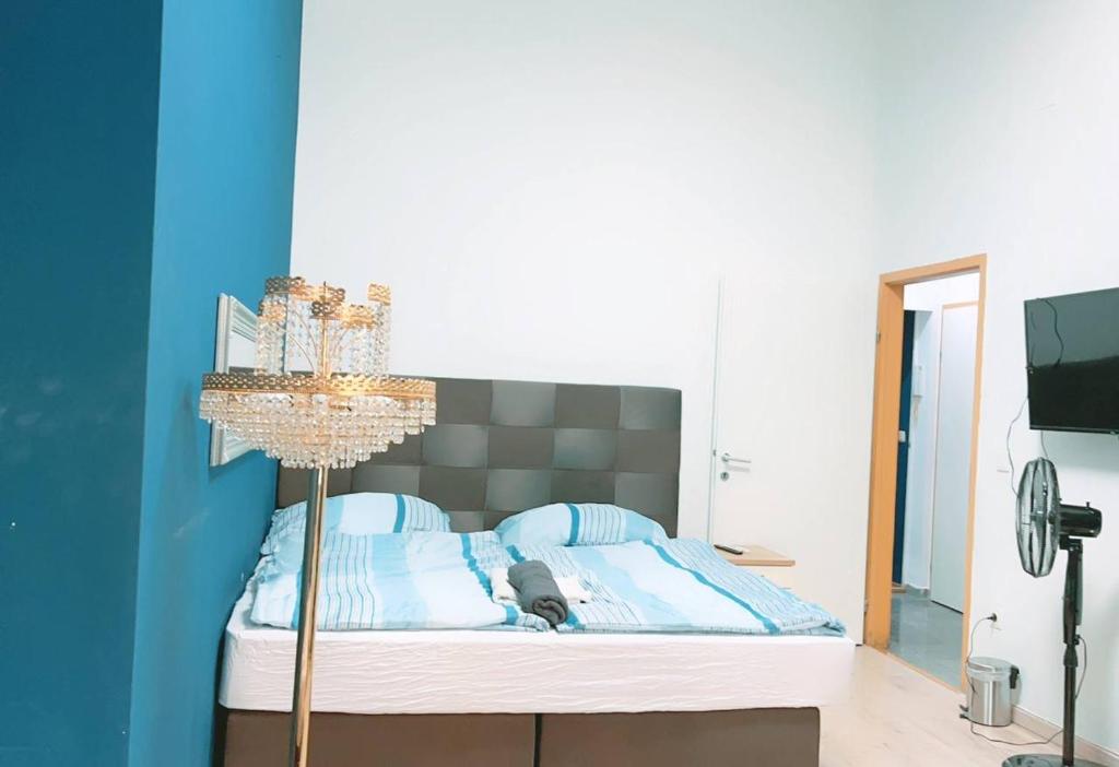 Schlafzimmer mit einem Bett mit blauer Wand in der Unterkunft Comfort Studio in City center KM1 in Wien