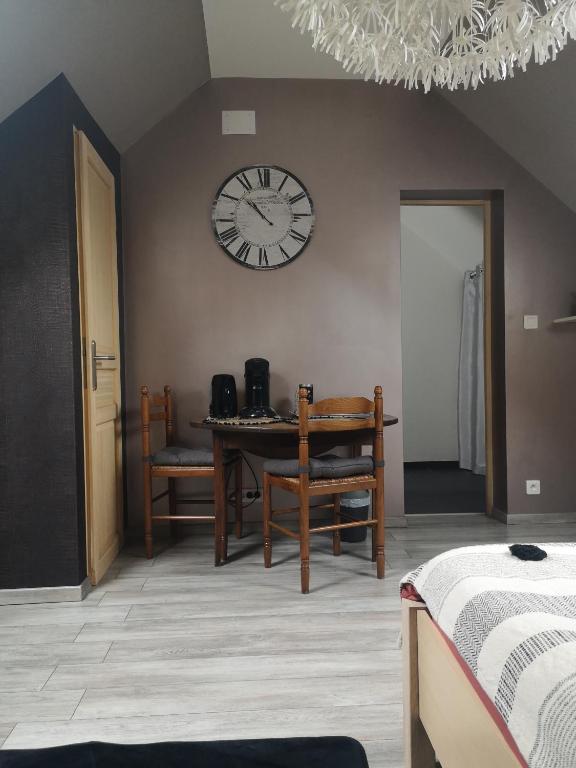 una habitación con una mesa y un reloj en la pared en Agréable chambre privée avec entrée indépendante, en Langeais