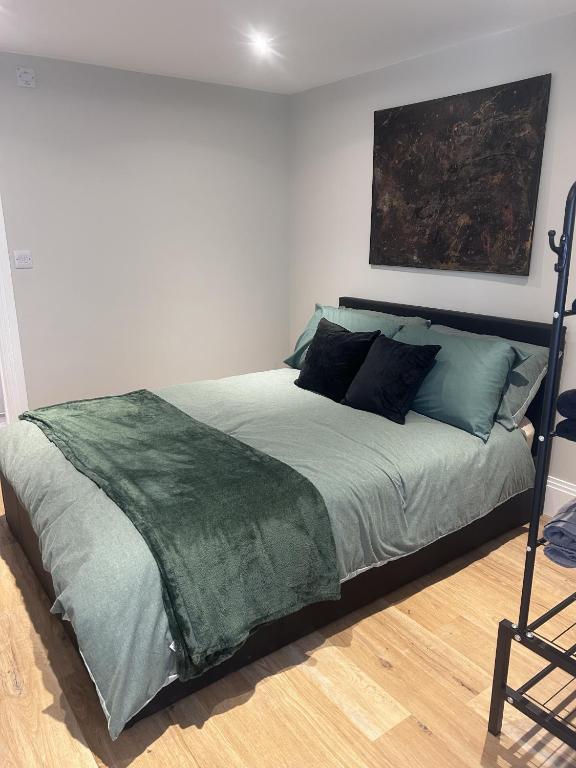 a bedroom with a bed with a green comforter at The Greenhouse in Wick