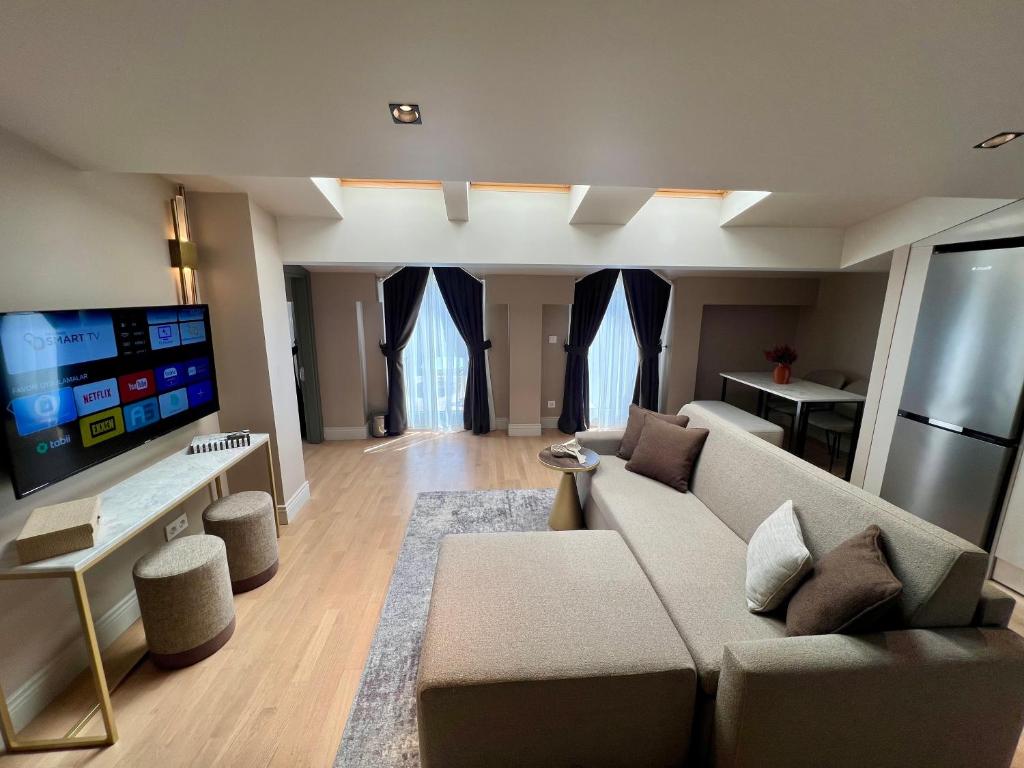 a living room with a couch and a flat screen tv at Weingart Suites Hotel in Istanbul