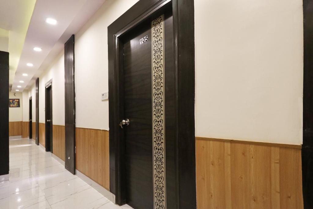 a row of black doors in a hallway at Flagship Hotel Sangeet in Faridabad