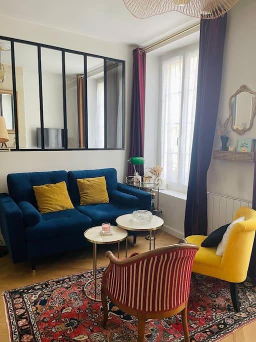 un salon avec un canapé bleu et une table dans l'établissement Appartement coup de cœur, à Caen