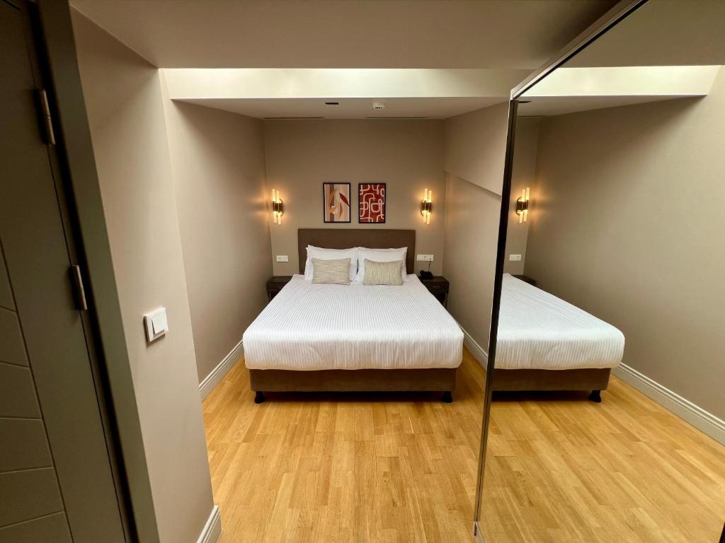 a small room with a bed and a mirror at Weingart Suites Hotel in Istanbul