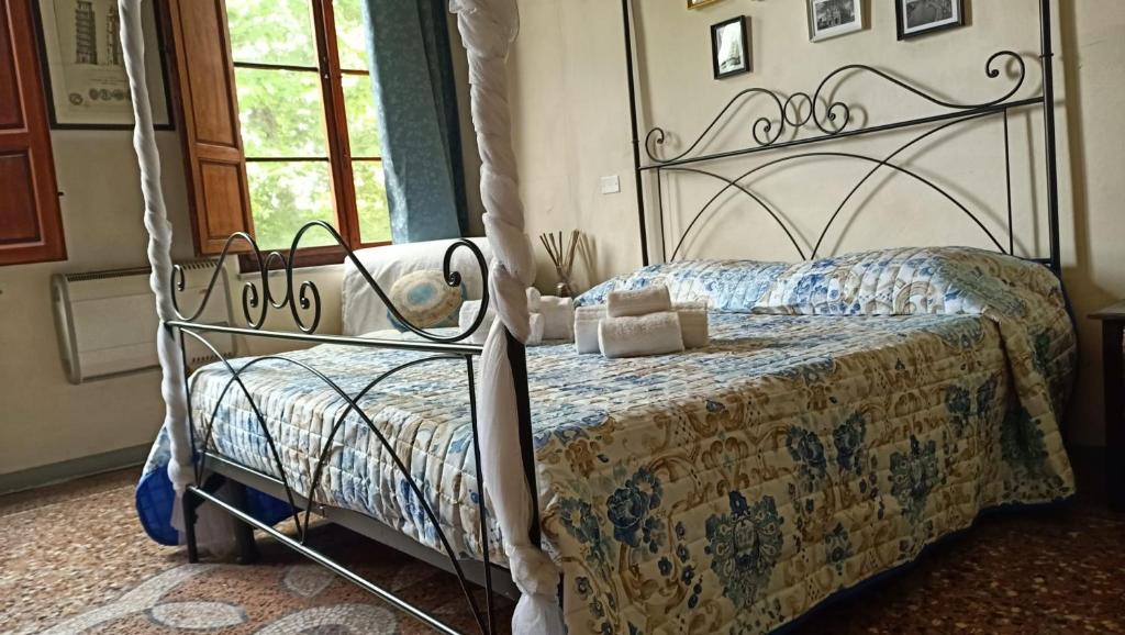una camera con letto con struttura metallica di Dimora del Conte a Pisa