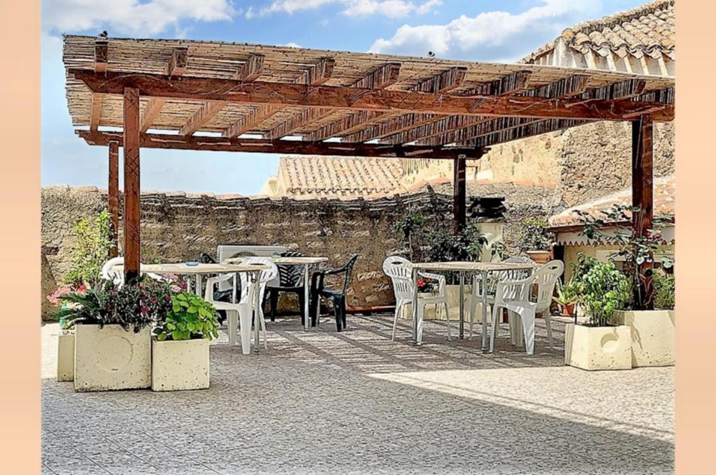 een patio met tafels en stoelen onder een houten pergola bij 2 bedrooms apartement with terrace at Galtelli in Galtellì