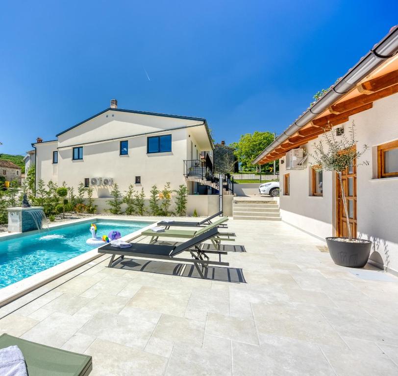 a patio with lounge chairs and a swimming pool at Casa Fortunato with Private Pool in Pićan