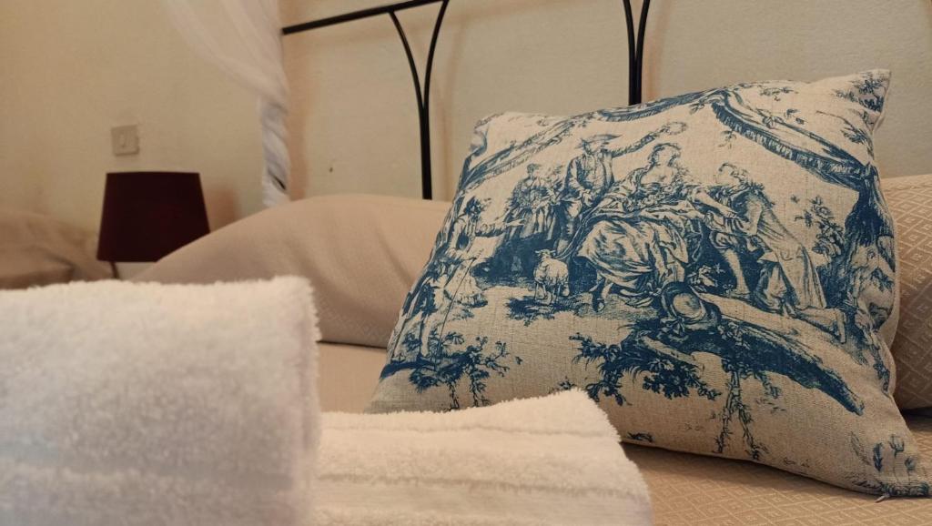 uma almofada azul e branca sentada em cima de uma cama em Dimora del Conte em Pisa