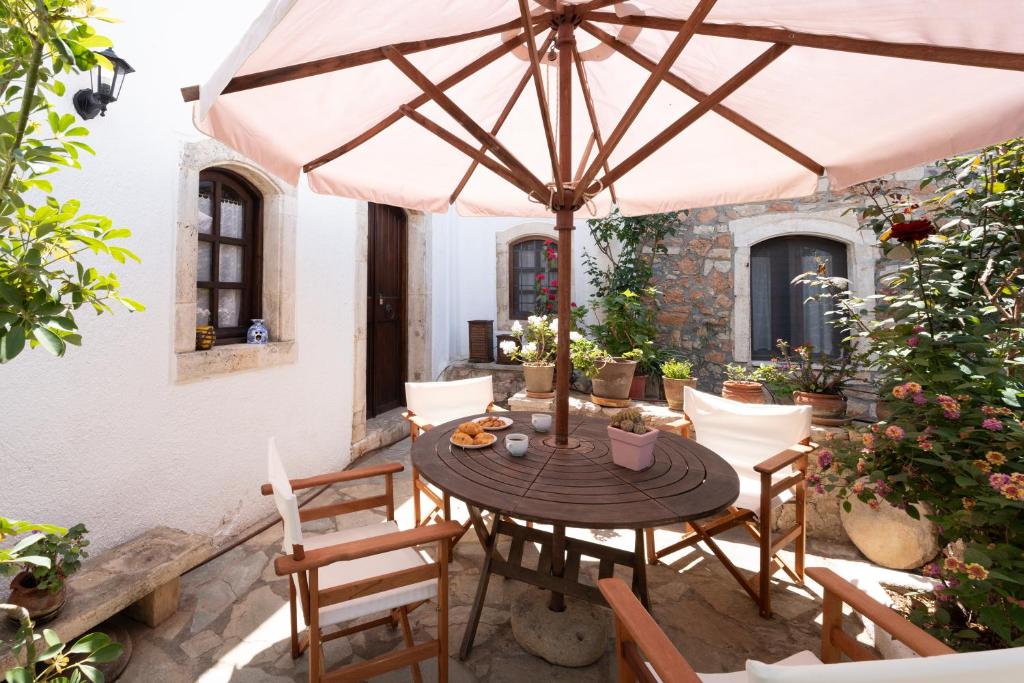 a patio with a table with an umbrella at Ilianthos Traditional Maisonette in Hersonissos