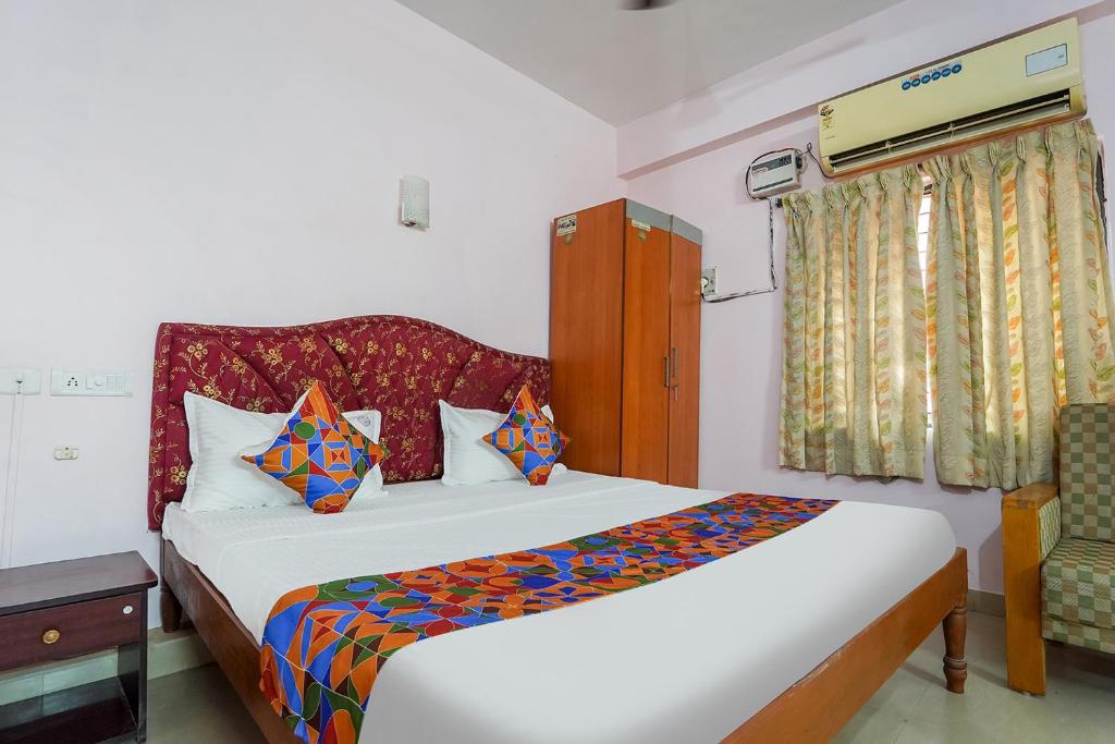 um quarto com uma cama e uma cadeira em FabHotel Terra em Chennai