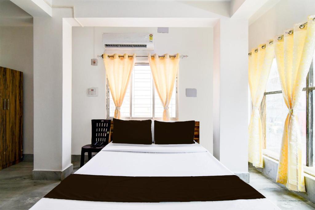 1 dormitorio con cama blanca y ventana en OYO RELAXING PARADISE, en kolkata