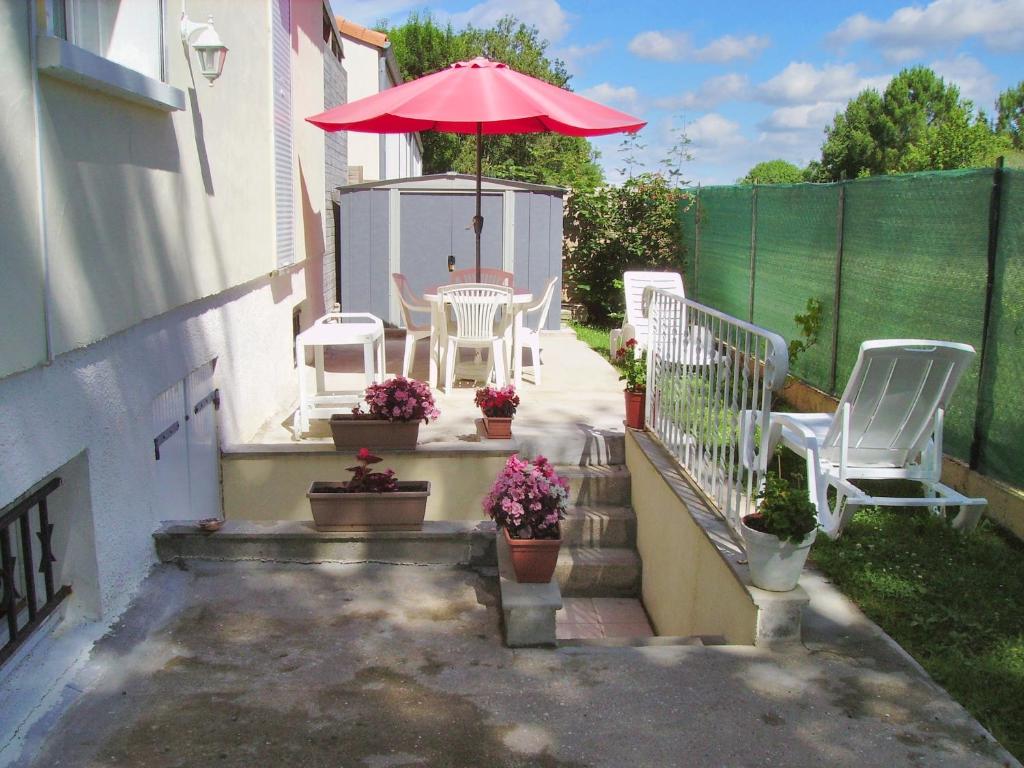 a patio with a table and chairs and an umbrella at Appartement de 2 chambres avec jardin clos et wifi a Breuillet in Breuillet