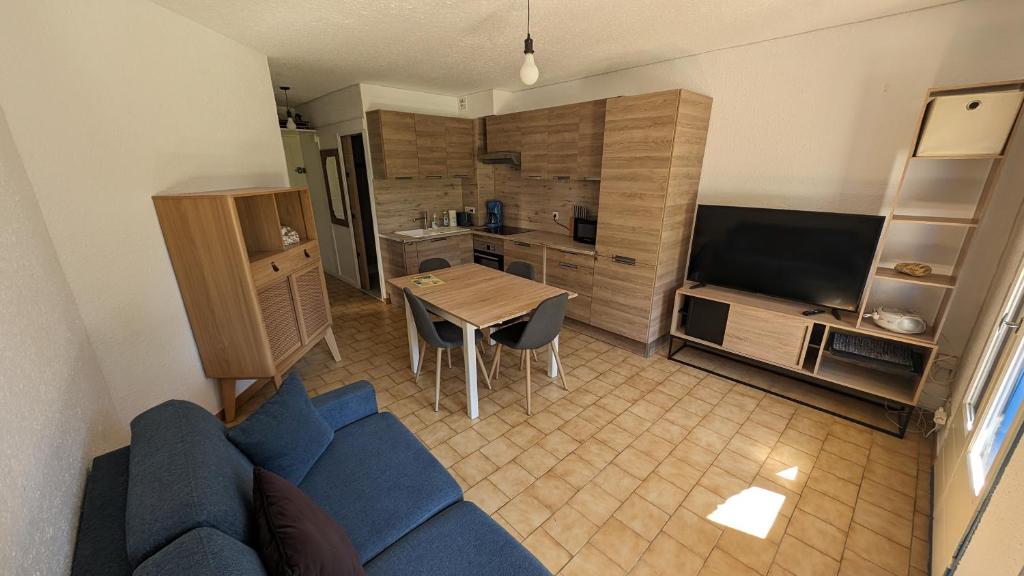 un salon avec un canapé bleu et une table dans l'établissement Magnifique T2 - Santa Cruz 62, à Canet
