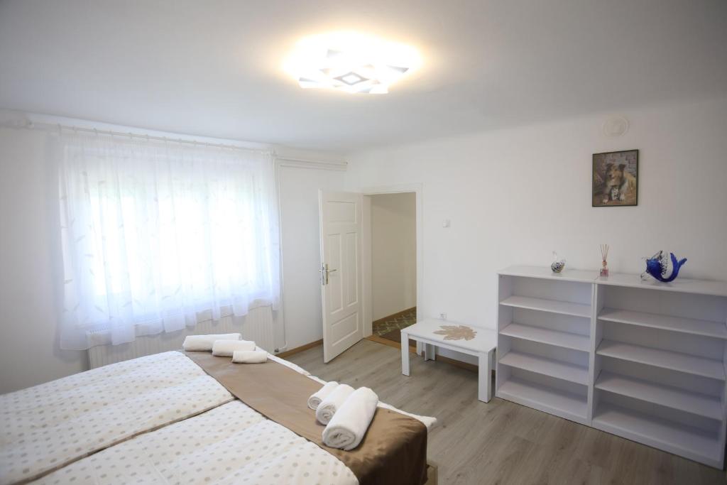 biała sypialnia z łóżkiem i komodą w obiekcie Apartment Sončni Gaj w Ptuju